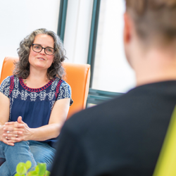Woman mental health worker speaking to a patient in a clinical setting