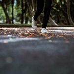 Cropped image of feet walking on a footpath through a park